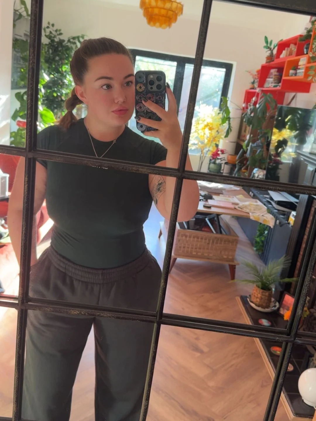 Em taking a mirror photograph in a cafe