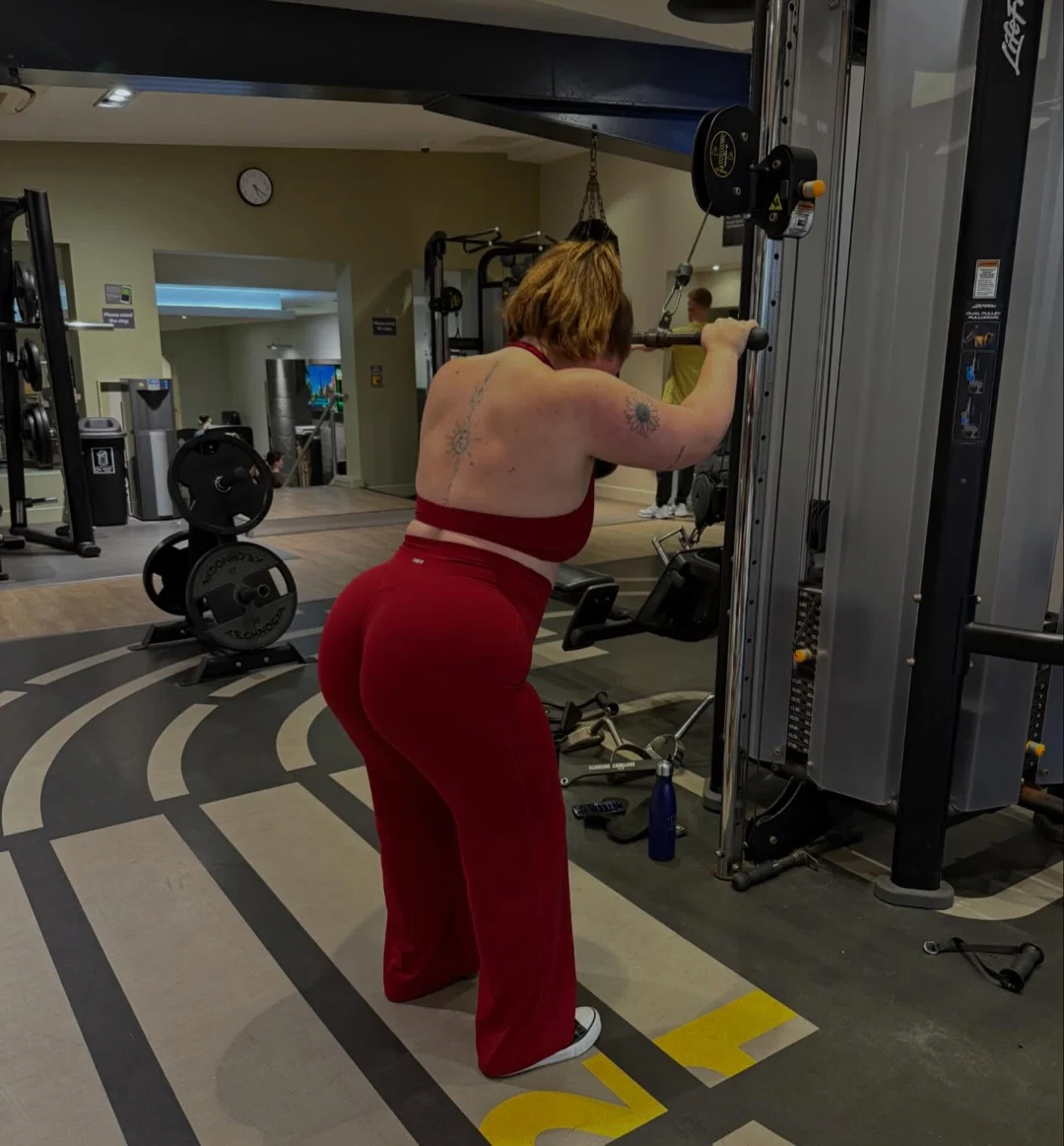 Em wearing red gymwear during a back training session